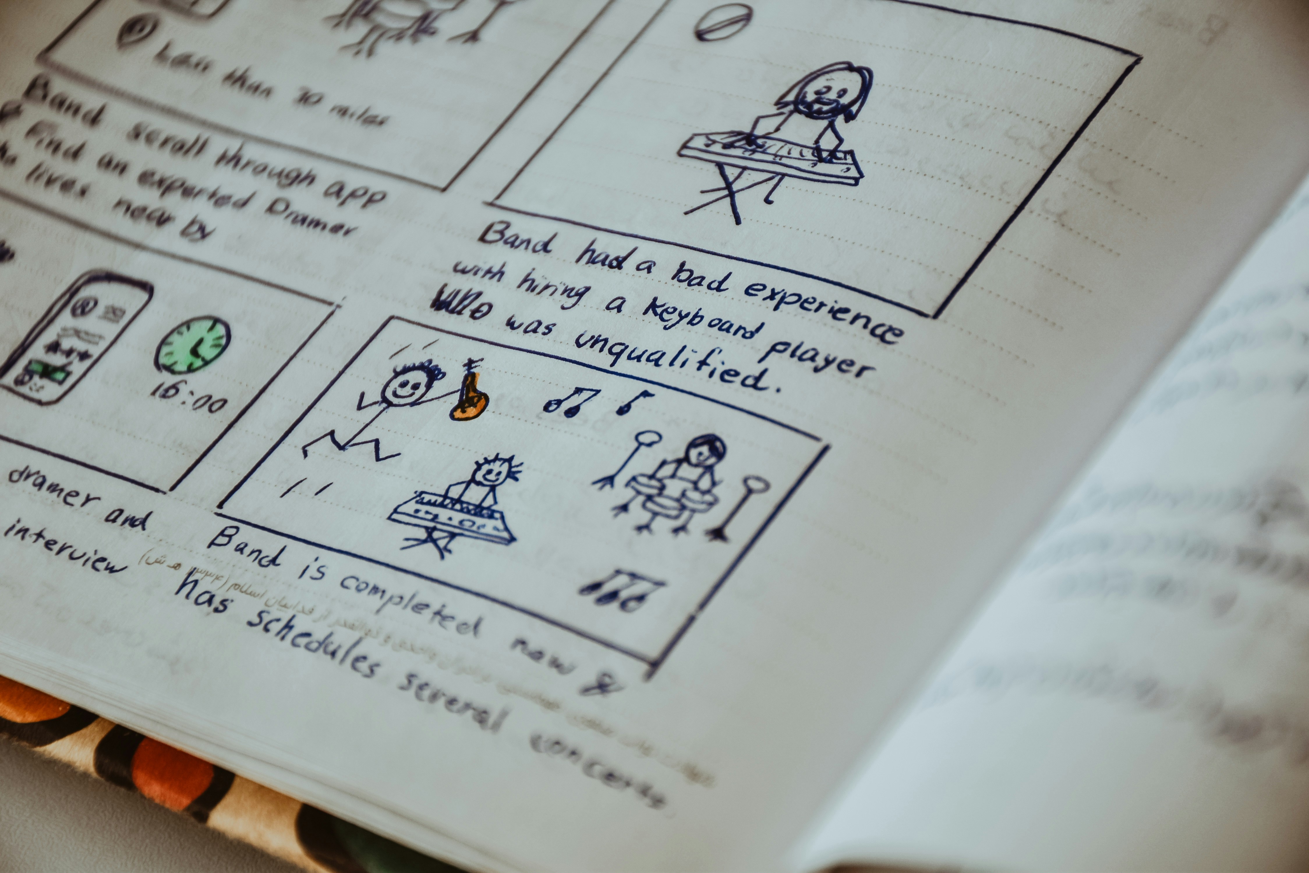 Hand-drawn storyboard sketches in a notebook showing a band hiring story
